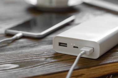 powerbank ve ahşap masa, modern araçlar arka plan üzerinde cep telefonu 