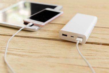 powerbank ve ahşap masa, modern araçlar arka plan üzerinde cep telefonu 