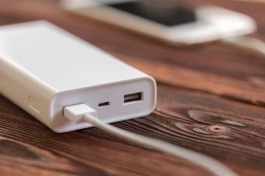 powerbank ve ahşap masa, modern araçlar arka plan üzerinde cep telefonu 