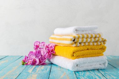 Orkide çiçekleri ile ahşap masa banyo Havlu yığını