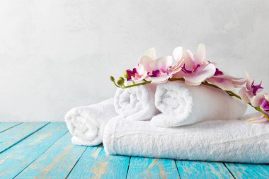 Orkide çiçekleri ile ahşap masa banyo Havlu yığını