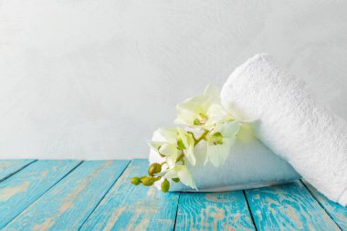 Orkide çiçekleri ile ahşap masa banyo Havlu yığını