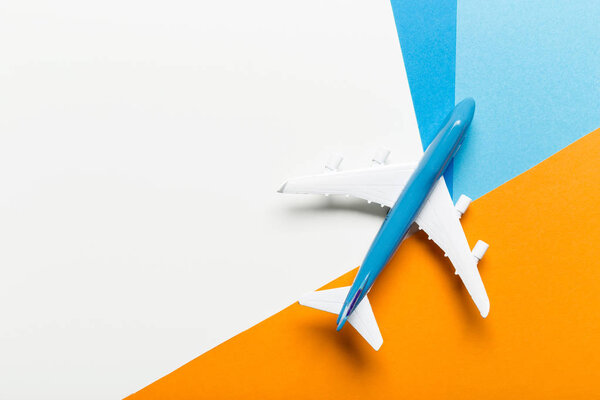 Миниатюрный самолет на красочном фоне для путешествия темы
