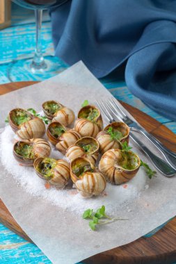 Sarımsak tereyağı ve taze otlar ile pişmiş salyangoz