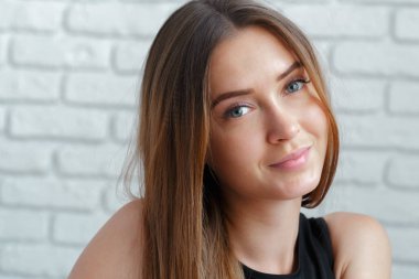 Tuğla duvar arka plan üzerinde genç kadın portresi 