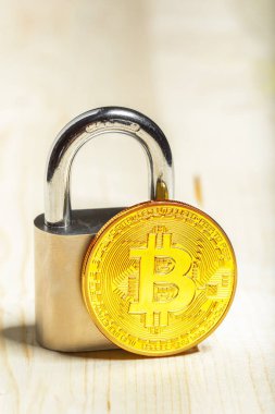 Altın bitcoin ve ahşap yüzey üzerinde asma kilit