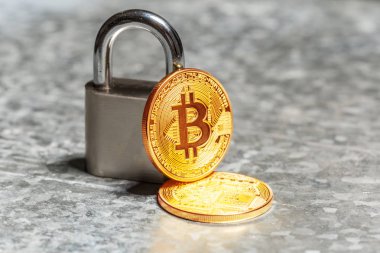 Altın bitcoins ve asma kilit gri yüzeyi