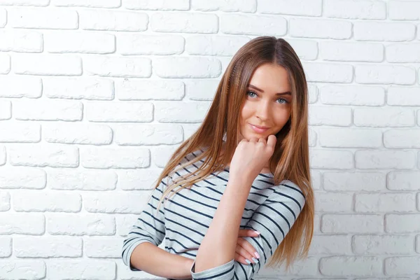 Portrait of young woman on brick wall background