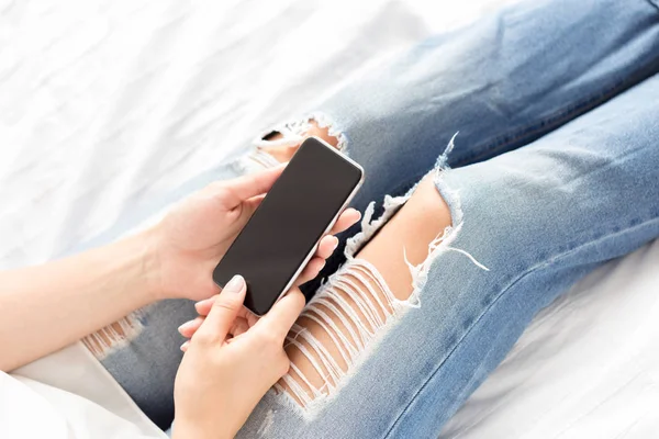 Woman checking the cellphone on the bed