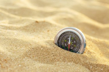 Kum üzerinde gümüş manyetik pusula