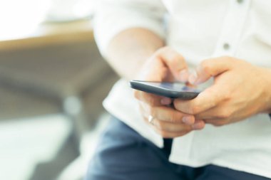 Kahve dükkanında Smartphone kullanan adam