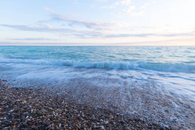 Deniz Taşlı bir plajda sörf.