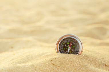 Kum üzerinde gümüş manyetik pusula