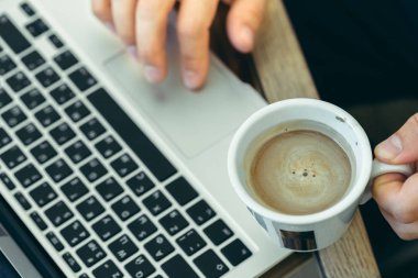 Genç adam bir dizüstü bilgisayarda gerçekleştiren