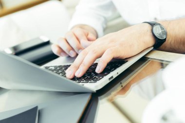 Genç adam bir dizüstü bilgisayarda gerçekleştiren