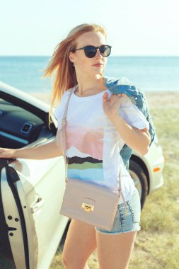 Genç kadın bir araba sahilde