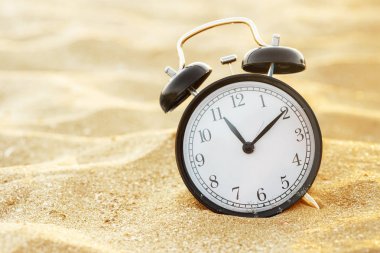 bir çalar saat sabah yaz zaman ayarlama bir plaj kum üzerinde closeup