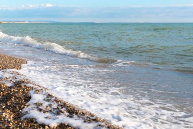 Deniz Taşlı bir plajda sörf.