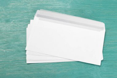 ahşap masa üzerinde beyaz zarfları