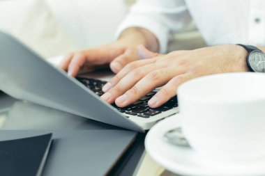 Genç adam bir dizüstü bilgisayarda gerçekleştiren