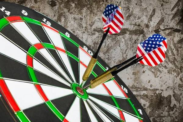 dart arrows hitting in the target center of dartboard