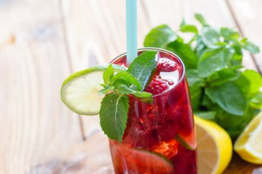 Yaz içeceği ahududu, kireç ve buz üzerinde eski bir ahşap masa