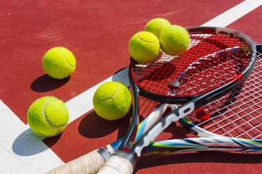 Tenis topları ve raketleri çim sahada