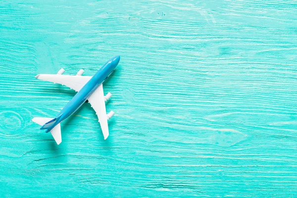 Closeup of miniature airplane on colored background. Travel or vacation concept