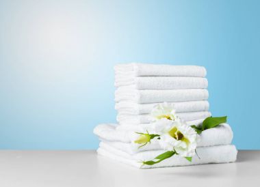 Beyaz masa üzerinde çiçekli havlu yığını