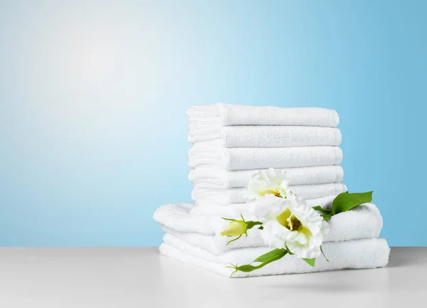 Stack of towels with flower on white table