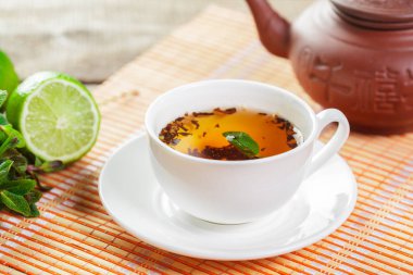 Ahşap masanın üstüne nane aromalı çay yaprakları