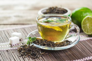 Ahşap masanın üstüne nane aromalı çay yaprakları