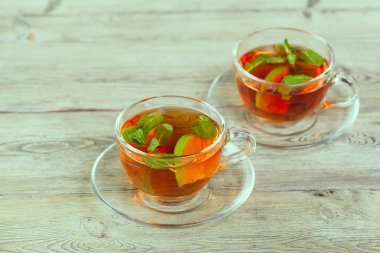 Ahşap masanın üstüne nane aromalı çay yaprakları