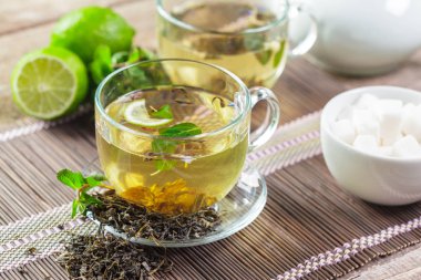 Ahşap masanın üstüne nane aromalı çay yaprakları