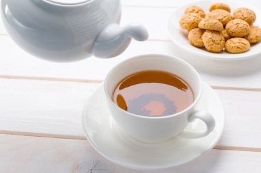 ahşap masa üzerinde çay kapatır