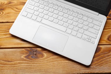 Laptop, defter üzerinde ahşap çalışma masası 