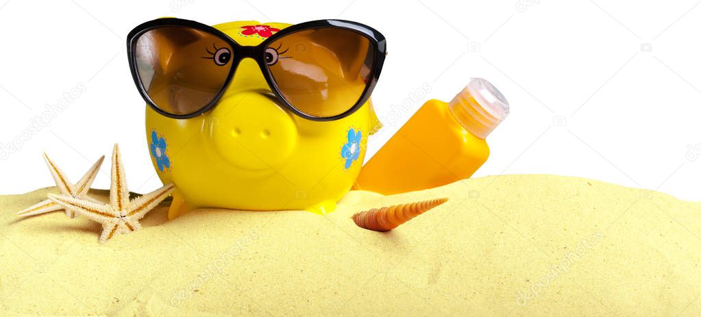 Summer piggy bank with sunglasses on the beach