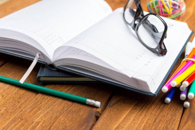 Ofis ahşap masasında boş not defteri.