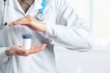 Doktor holding şişe hap ile