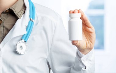 Doktor holding şişe hap ile