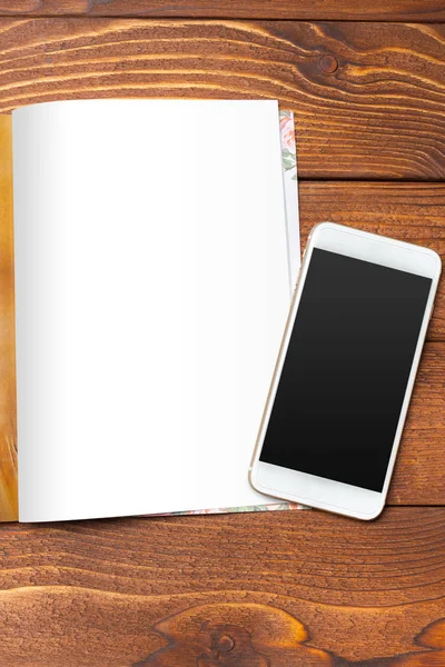 Blank book or magazine cover with mobile phone on wood background