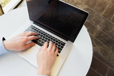 Beyaz adam masada dizüstü bilgisayar kullanarak