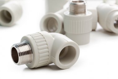 Metal-plastik tesisat bağlantıları, adaptörler, beyaz arka planda izole edilmiş prizler.