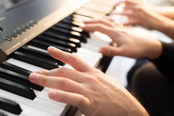 Closeup of hands playing piano. Music and hobby concept.