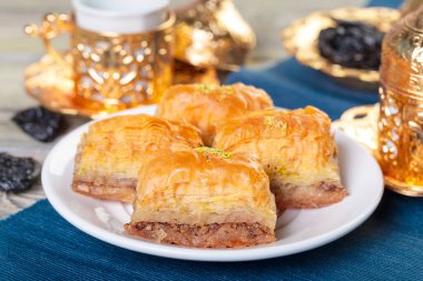 Koyu arkaplanda çay bulunan geleneksel Türk Tatlısı Baklava.