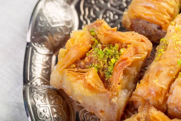 Turkse snoepjes baklava en metalen oosterse dienblad op houten ondergrond — Stockfoto