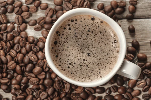木製の背景にコーヒーと豆のカップ。創作写真 — ストック写真