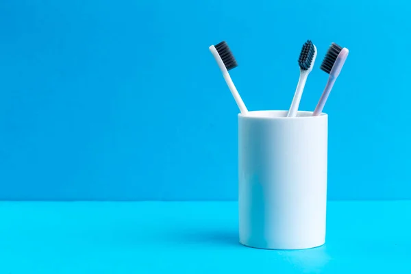 Escovas de dentes em vidro na mesa. foto criativa — Fotografia de Stock