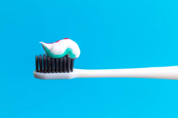 Toothbrush and toothpaste on blue. creative photo — Stock Photo, Image
