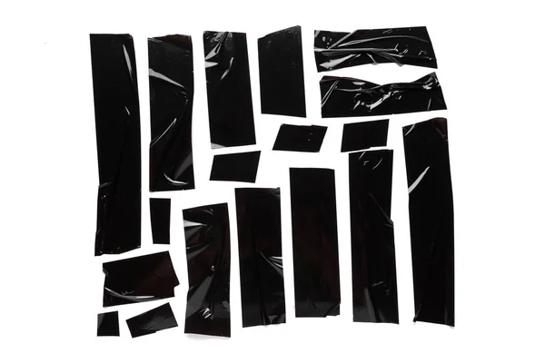 A collection of used black electrical tape pieces isolated on white background. — Stock Photo, Image